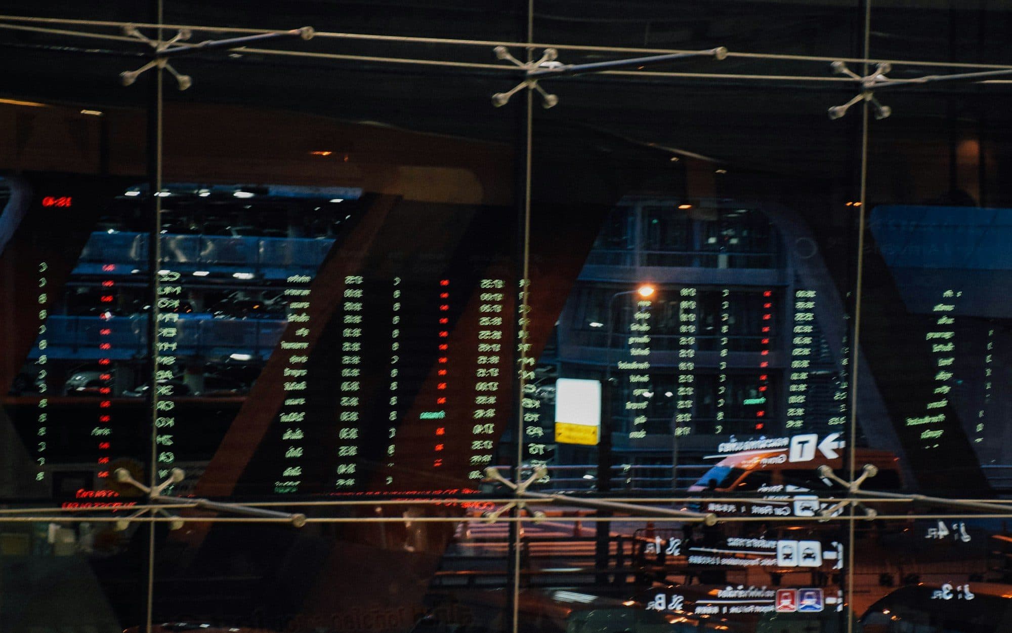 Glowing market tickers and data panels in a dark trading hall