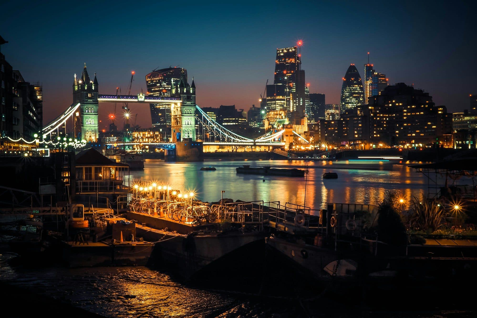 Tower Bridge and the City of London illuminated at night over the Thames